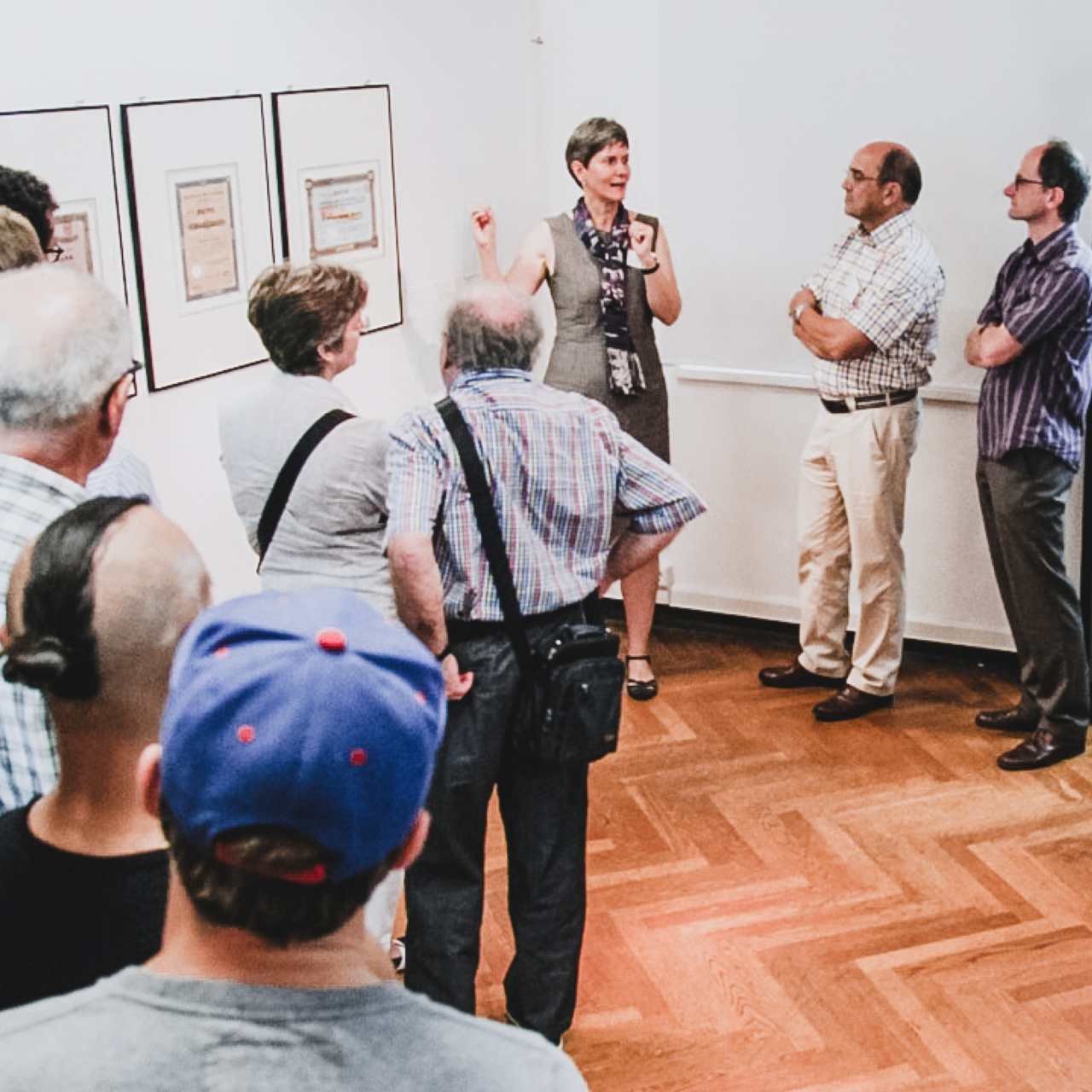 Im Museum für Druckkunst stehen die Gäste vor den Ausstellungsobjekten und bekommen dieses von einer Museumsmitarbeiterin erklärt.