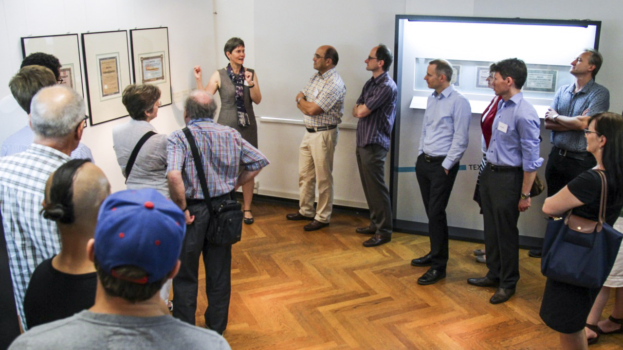 Teilnehmer der Veranstaltung stehen vor einem Exponat im Museum für Druckkunst